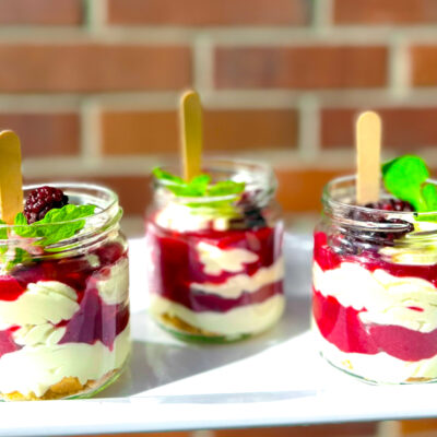 Deser w słoiczkach z białą czekoladą, musem malinowym i miętą – Cynamon Catering.