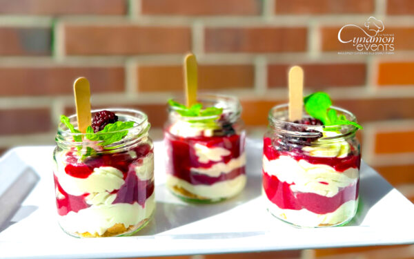 Deser w słoiczkach z białą czekoladą, musem malinowym i miętą – Cynamon Catering.